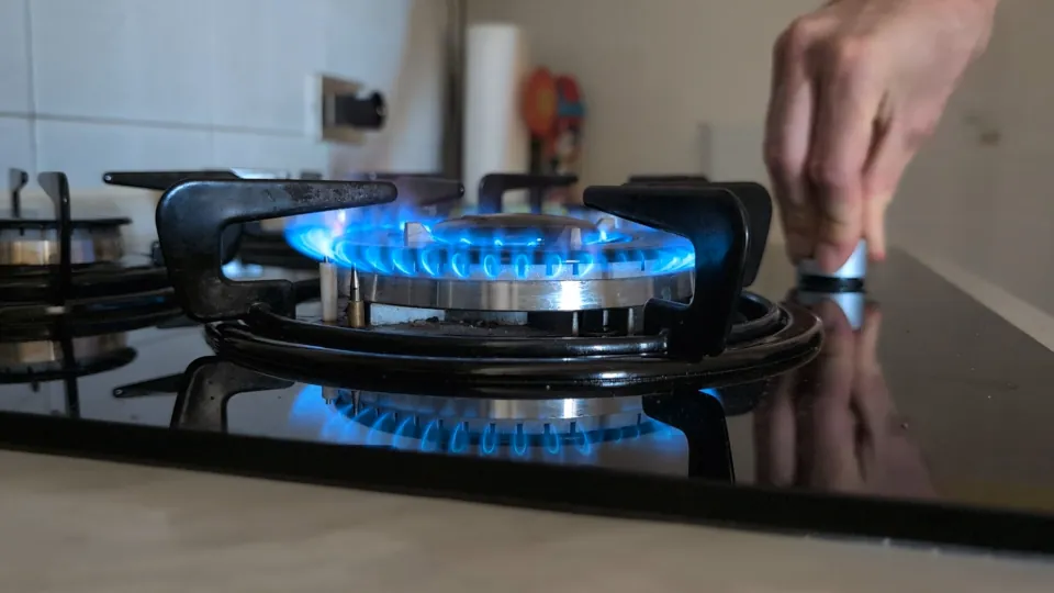 Fornello a gas acceso che sarà sostituito con un piano cottura a induzione